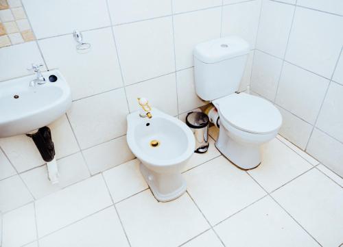 a bathroom with a toilet and a sink at Ehrlichpark Lodge self catering and spa in Bloemfontein