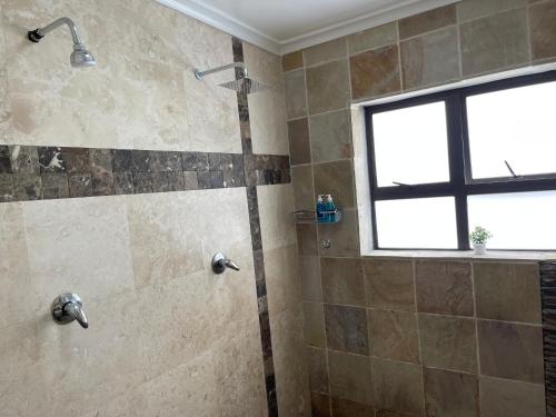 a bathroom with a shower with a shower head at Maita Guest in Cape Town