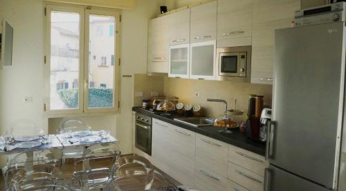cocina con armarios blancos y nevera de acero inoxidable en B&B Terrazza Belfiore en Florence