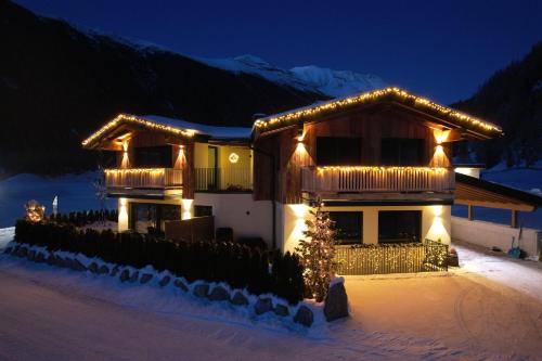 a house with christmas lights on it in the snow at Alp Apart Niederthai in Umhausen