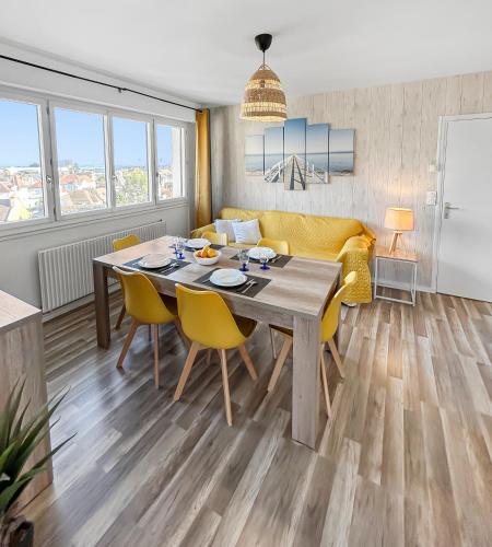 un salon avec une table et des chaises jaunes dans l'établissement Lumineux, vue dégagée, et plage à pied, à Ouistreham