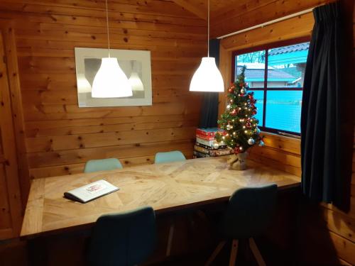 a dining room with a christmas tree and a table at Lupine Lodge in Gramsbergen