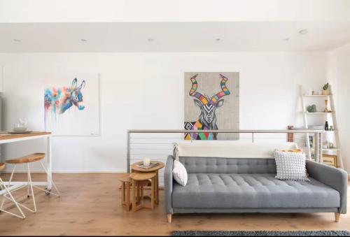 a living room with a couch and a table at Designer townhome adjacent to East Brunswick Village 2min to tram plus private parking in Melbourne