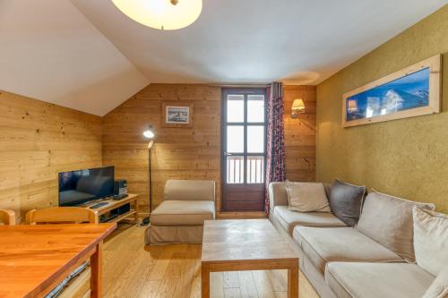a living room with a couch and a tv at Chalet le Regain in Villard-Reculas