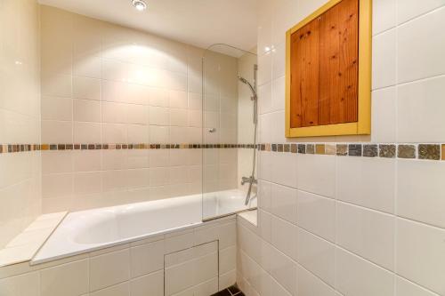 a bathroom with a bath tub and a wooden cabinet at Chalet le Regain in Villard-Reculas