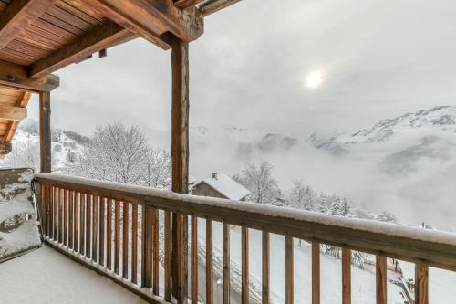 a view from a cabin balcony with snow covered mountains at Chalet le Regain in Villard-Reculas