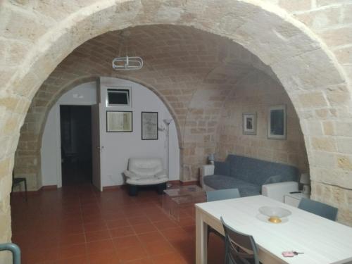 a living room with a couch and a table at Casa vacanza nel cuore della pietra in Barletta