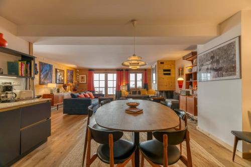 une cuisine et un salon avec une table et des chaises dans l'établissement Klochette - Charme Et Famille, à Villard-Reculas