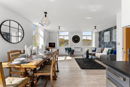a dining room and living room with a dining table at 30 percent off! Beautiful Apartment in Dewsbury - Sleeps 6 in Leeds