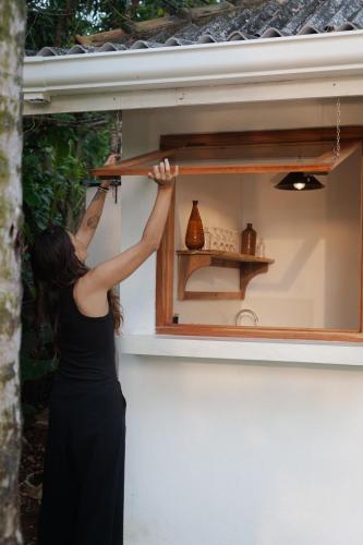 a woman in a black dress looking into a window at Studio Morell in Ahangama