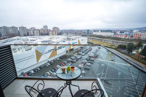 a balcony with a view of a parking lot with cars at Delta Lux Apartman in Niš
