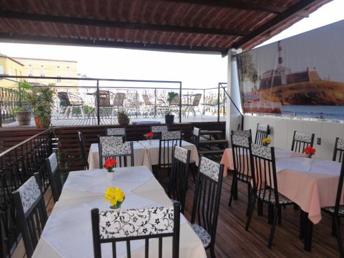 Un restaurante con mesas y sillas en un balcón. en Pousada Bahia Morena, en Salvador