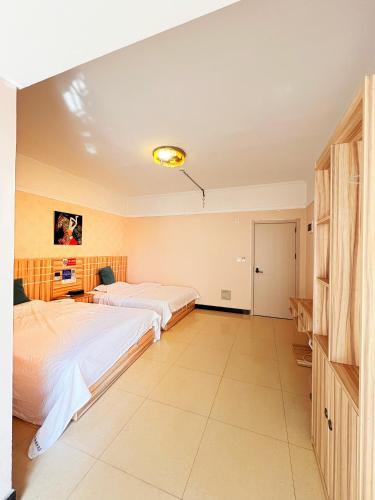 a bedroom with two beds and a desk at MAXHILL inn悦季时光酒店 in Jinghong
