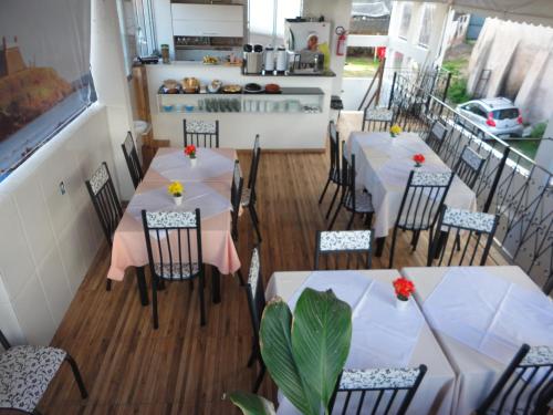 Un restaurante con mesas y sillas en una sala. en Pousada Bahia Morena, en Salvador