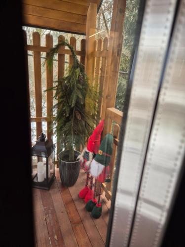 a figurine of santa on a porch with a christmas tree at Apartament z prywatna wanną hydromasaż - U Parów in Białka Tatrzanska