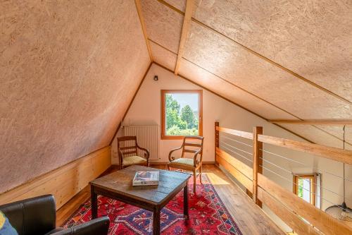 a room with a table and chairs in a attic at le Shed - gîtes de Banne 70 in Sornay