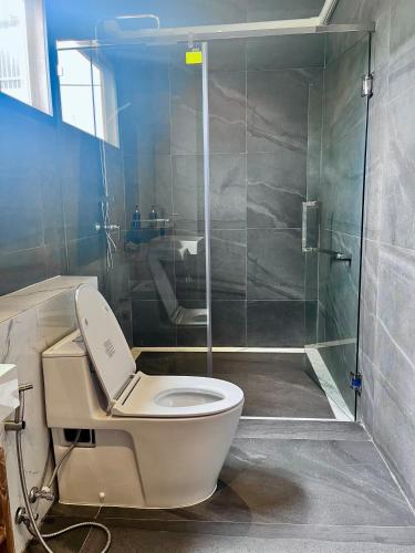 a bathroom with a toilet and a glass shower at The Chic Lipe in Ko Lipe