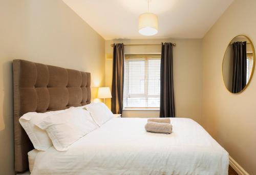 a bedroom with a large bed and a window at The Picasso - Trendy 2 bd Ap- Dublin 4 - Super Fast WIFI in Dublin