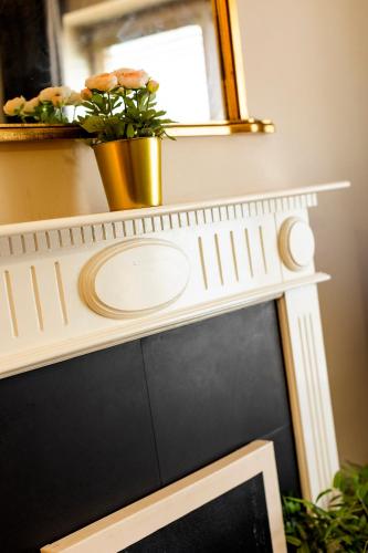 a white mantel with a mirror and a plant at The Picasso - Trendy 2 bd Ap- Dublin 4 - Super Fast WIFI in Dublin