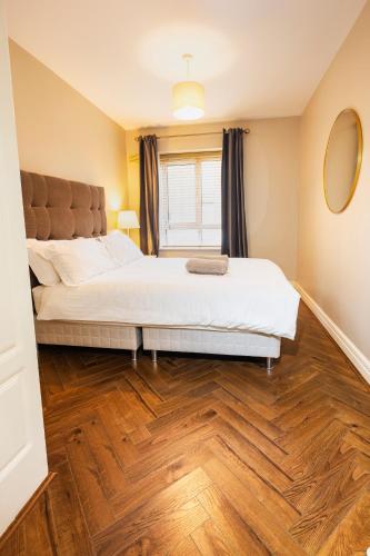 a bedroom with a large bed and a wooden floor at The Picasso - Trendy 2 bd Ap- Dublin 4 - Super Fast WIFI in Dublin