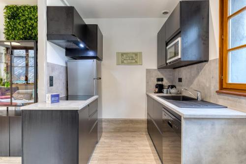 une cuisine avec un évier et un réfrigérateur dans l'établissement Bezuel votre F3 avec parking en centre ville, à Rouen