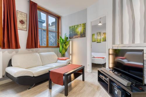 un salon avec un canapé et une télévision dans l'établissement Bezuel votre F3 avec parking en centre ville, à Rouen