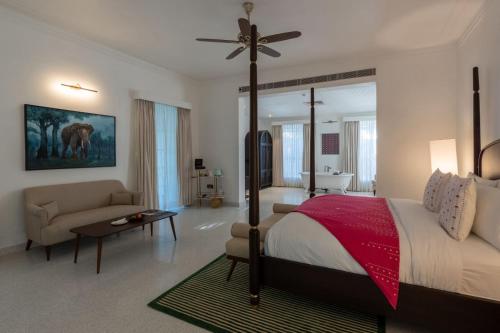 a bedroom with a large bed and a living room at The Postcard in the Durrung Tea Estate, Assam in Tezpur