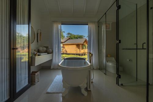 a large bathroom with a tub and a window at The Postcard in the Durrung Tea Estate, Assam in Tezpur