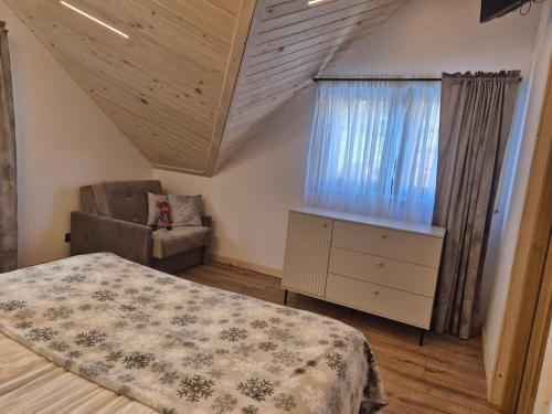 a bedroom with a bed and a chair and a window at Apartament z prywatna wanną hydromasaż - U Parów in Białka Tatrzanska