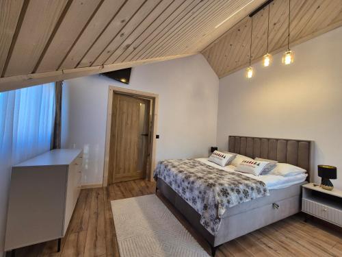 a bedroom with a bed and a wooden ceiling at Apartament z prywatna wanną hydromasaż - U Parów in Białka Tatrzanska