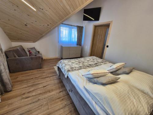 a bedroom with a large bed and a couch at Apartament z prywatna wanną hydromasaż - U Parów in Białka Tatrzanska