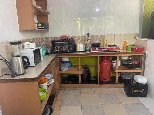 a kitchen with a counter top with a microwave and a counter sidx sidx at L&J Modern Backpackers Kinondoni in Dar es Salaam