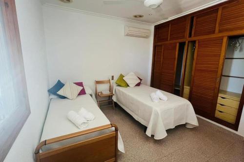 a bedroom with two beds and a table and chairs at Villa Iluminada con chimenea, barbacoa y piscina cerca Playa in Elche