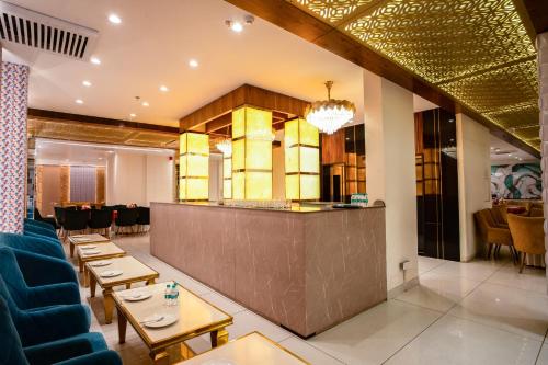 a restaurant with a bar and tables and chairs at ACR Luxury Hotel in Mohali