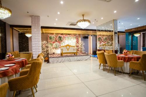 a banquet hall with tables and chairs and a stage at ACR Luxury Hotel in Mohali