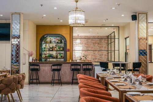 a restaurant with tables and chairs and a bar at ACR Luxury Hotel in Mohali