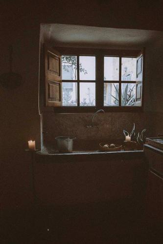 a kitchen with a window and a sink with a candle at Agroturismo Can Torna AG178 in Esporles