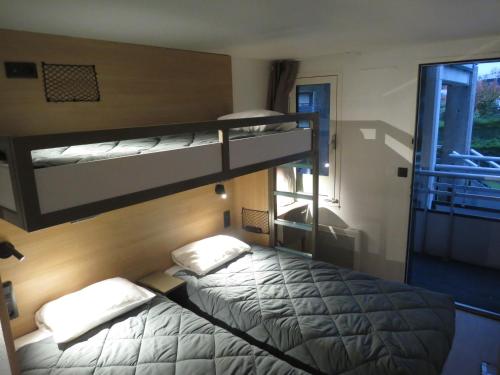 two bunk beds in a room with a window at HOTEL PREMIERE CLASSE Rouen Sud Oissel in Saint-Étienne-du-Rouvray