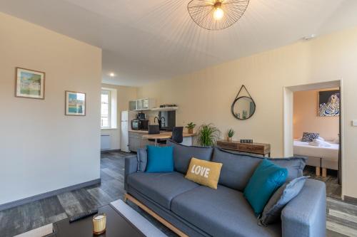 un salon avec un canapé bleu et une cuisine dans l'établissement Le petit Oberlin, entre Chambord et Zoo Beauval, à Cour-Cheverny