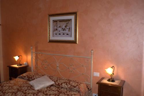 a bedroom with a bed and two night stands with lamps at La Portella in Fabriano