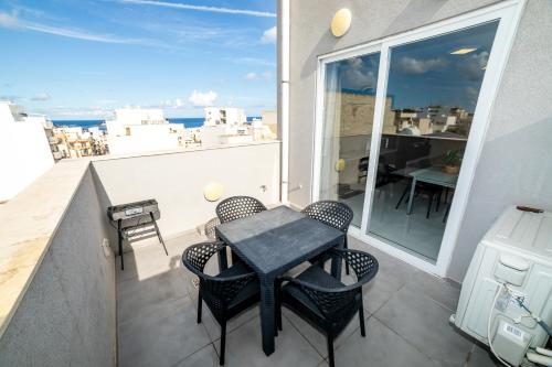 a small table on a balcony with a view of the ocean at New and Modern home in Bugibba, great location in St Paul's Bay