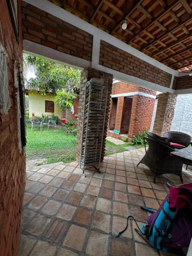 an outside patio with a table and a brick wall at Casa da praia Atins Maranhão in Atins