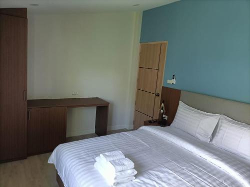 a bedroom with a white bed with two towels on it at The European Chiang Mai in Chiang Mai