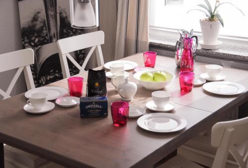 un tavolo da pranzo con candele rosa e piatti sopra di Minihotel Büchenbronn a Büchenbronn