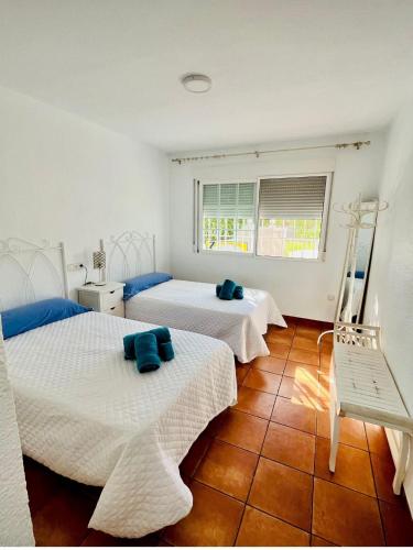 a bedroom with two beds and a window at Buganvilla 56 in Roquetas de Mar