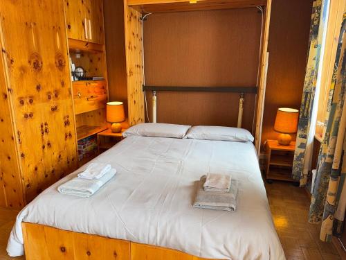 a bedroom with a large bed with towels on it at Family Chalet in Pila, Comfort and Fun in Pila