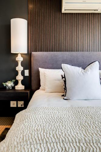 a bedroom with a large bed with white pillows at Villa Alexa in Cape Town