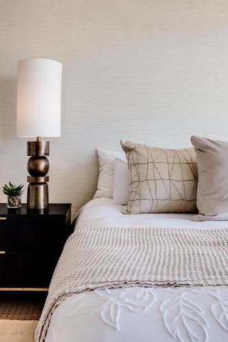 a bedroom with a white bed with a lamp at Villa Alexa in Cape Town