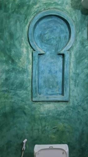 a painting of a window above a toilet in a bathroom at Lala House by Masala Living in Jambiani