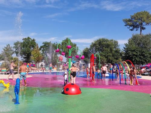 un groupe de personnes jouant dans un parc aquatique dans l'établissement Mobilhome 6 couchages grand confort Cap Ferret, à Lège-Cap-Ferret